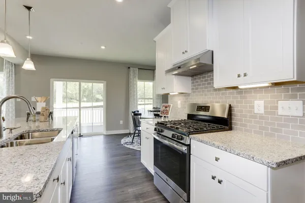a kitchen with stainless steel appliances granite countertop a stove a sink dishwasher and a refrigerator