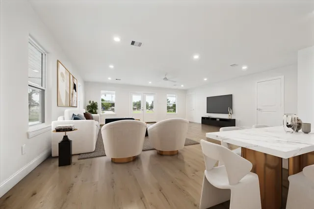 a living room with furniture a flat screen tv and kitchen view