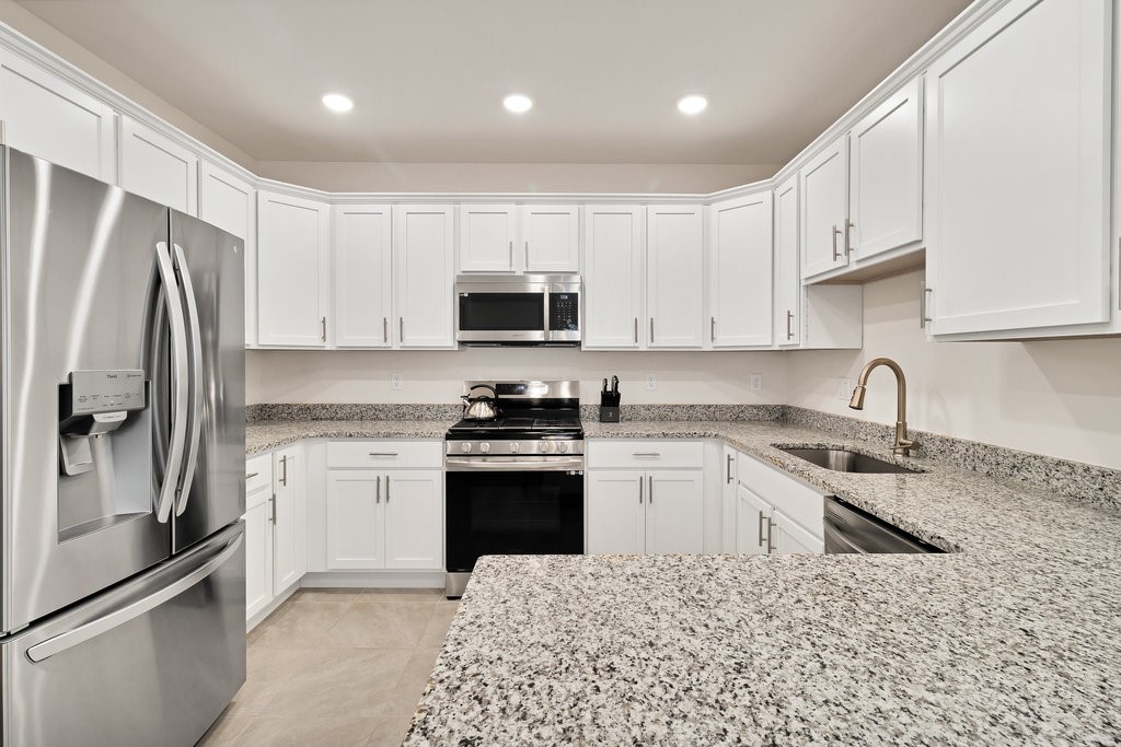 6035 Red Maple Manor Vero Beach, FL 32966 - Photo 11 of 36 a kitchen with stainless steel appliances granite countertop a refrigerator stove microwave and sink