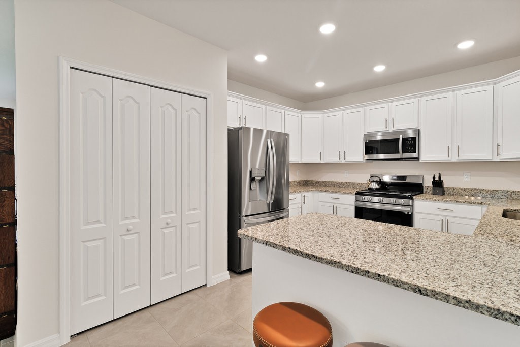 6035 Red Maple Manor Vero Beach, FL 32966 - Photo 12 of 36 a kitchen with granite countertop stainless steel appliances cabinets a sink and a counter top space