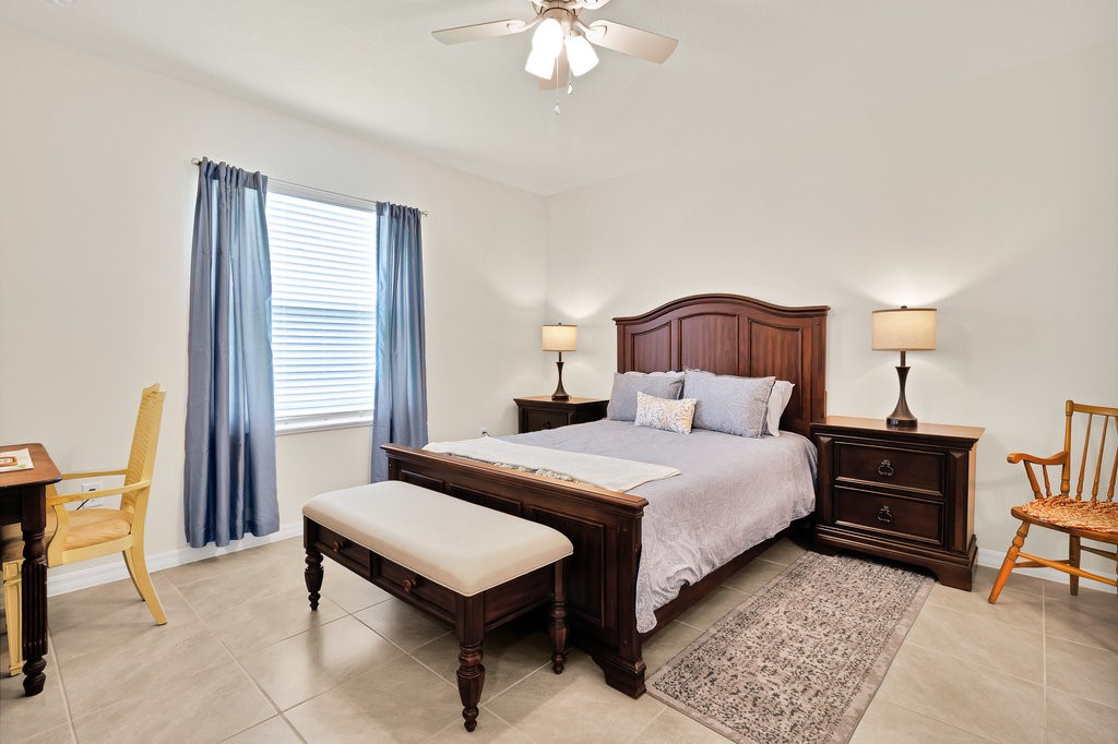 6035 Red Maple Manor Vero Beach, FL 32966 - Photo 14 of 36 a bedroom with a bed a lamp and a large window