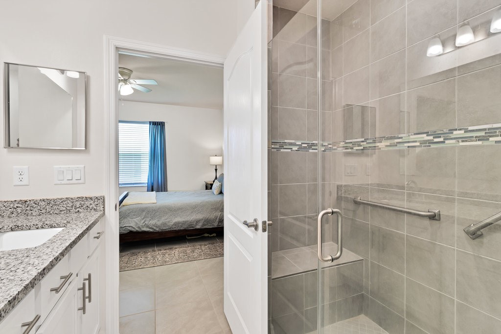 6035 Red Maple Manor Vero Beach, FL 32966 - Photo 17 of 36 a en suite bathroom with a granite countertop sink a toilet and shower