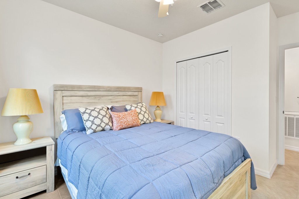 6035 Red Maple Manor Vero Beach, FL 32966 - Photo 19 of 36 a bedroom with a bed and a lamp on dresser