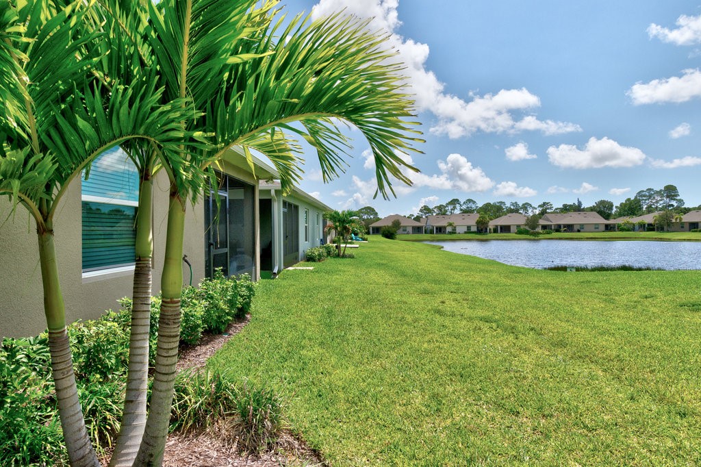 6035 Red Maple Manor Vero Beach, FL 32966 - Photo 29 of 36 a view of a house with a big yard and palm trees
