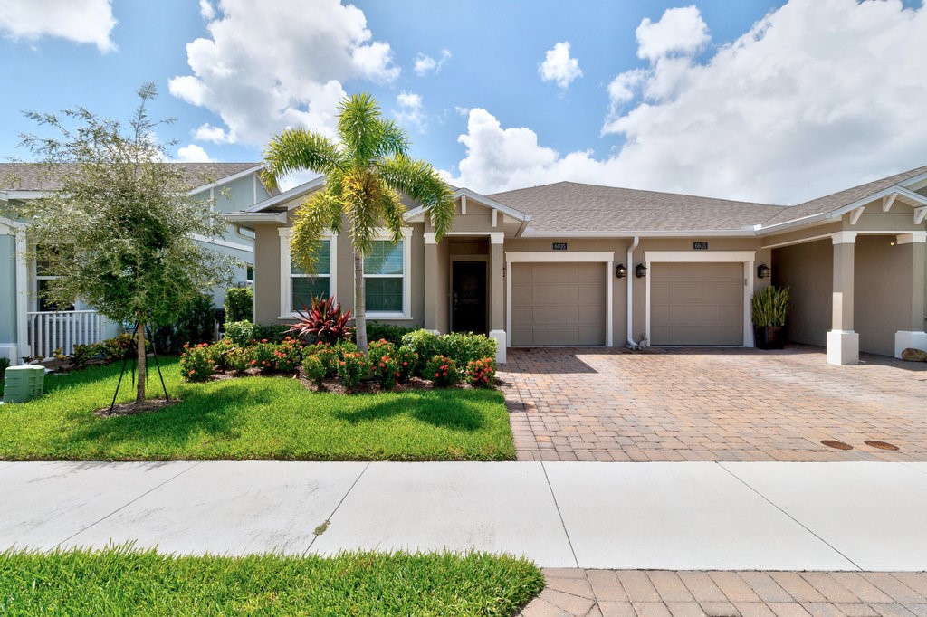 6035 Red Maple Manor Vero Beach, FL 32966 - Photo 31 of 36 a view of a white house with a yard and potted plants