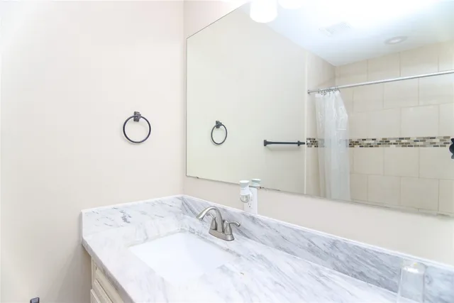 a bathroom with a granite countertop sink and a mirror