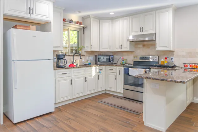a kitchen with white cabinets and white appliances
