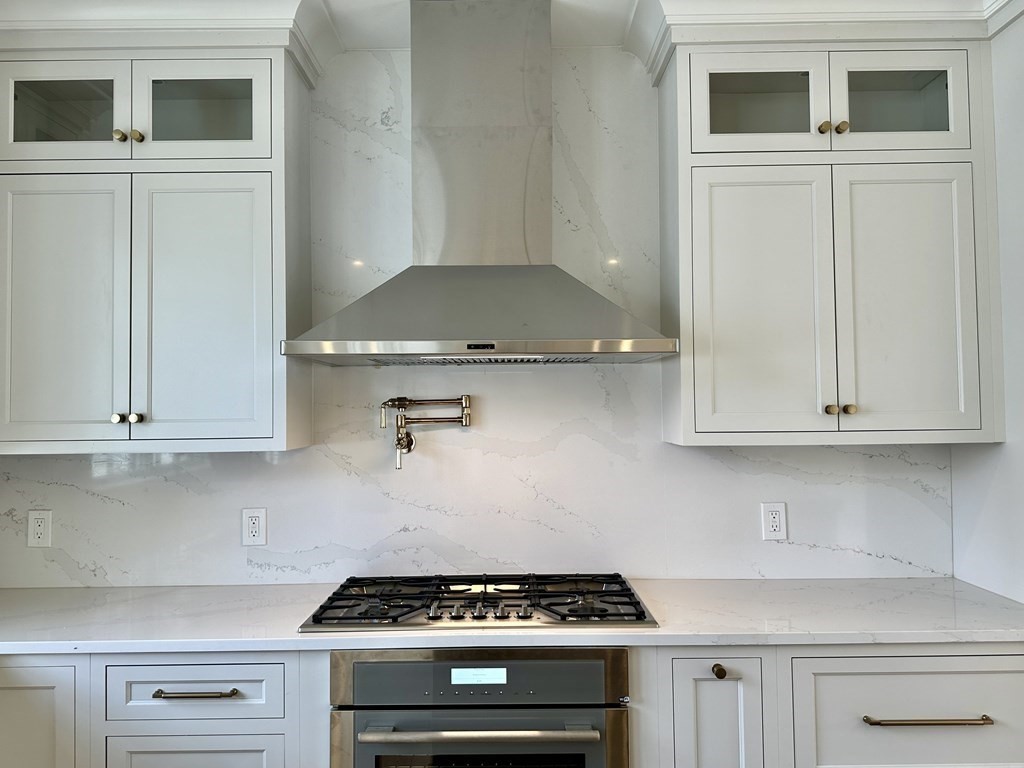 258 Reedsdale Road Milton, MA 02186 - Photo 6 of 34 a kitchen with granite countertop white cabinets and stainless steel appliances
