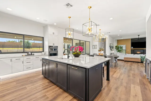 a kitchen with stainless steel appliances granite countertop a kitchen island a stove and a wooden floors