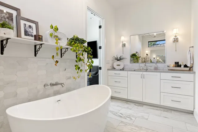 a spacious bathroom with a granite countertop sink and a bathtub