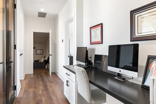 a view of a workspace with furniture and a window