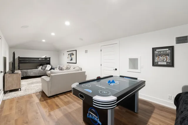 a living room with a table and a refrigerator