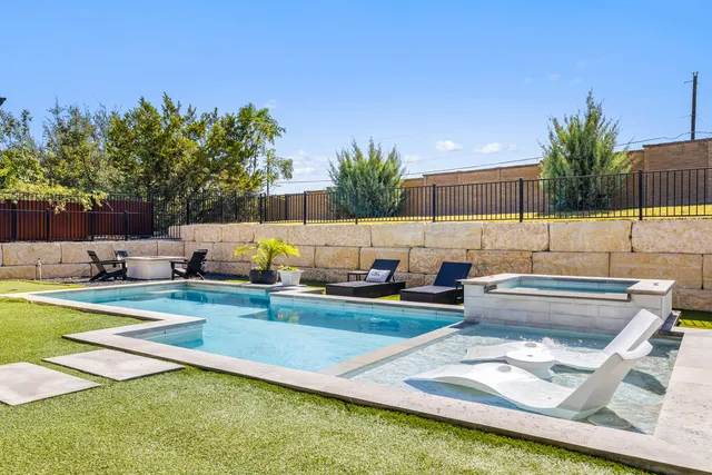 a view of a swimming pool with a patio and a yard