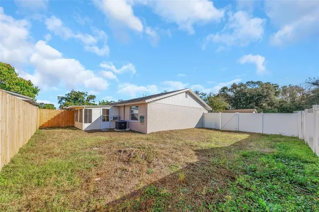 a view of a house with a yard and fence