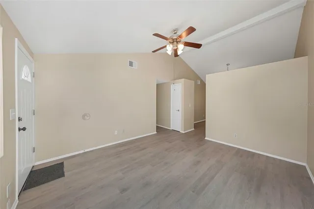 a view of an empty room with wooden floor