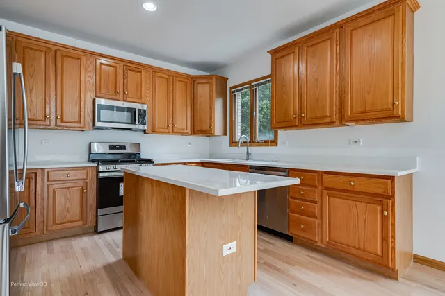 a kitchen with stainless steel appliances granite countertop a stove a sink dishwasher and a microwave oven with cabinets