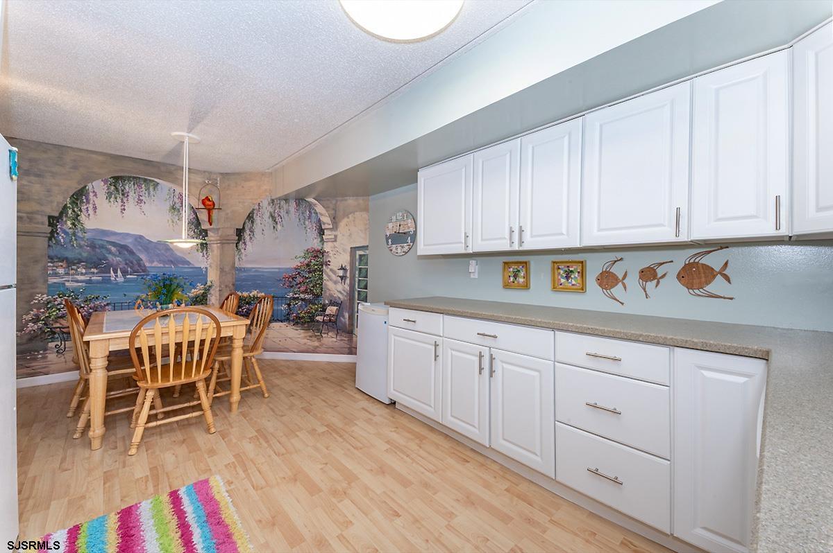 935 Ocean Avenue, Unit 315 Ocean City, NJ 08226 - Photo 11 of 37 a kitchen with stainless steel appliances granite countertop a sink dishwasher and cabinets with wooden floor