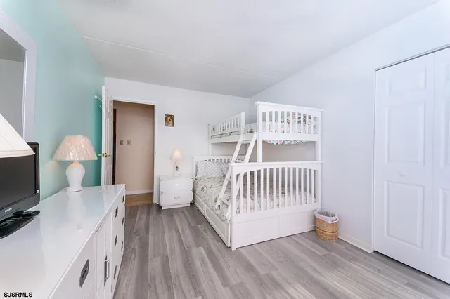 a view of a bedroom with furniture and wooden floor