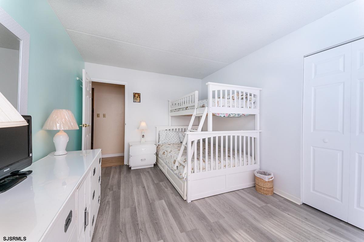 935 Ocean Avenue, Unit 315 Ocean City, NJ 08226 - Photo 17 of 37 a view of a bedroom with furniture and wooden floor