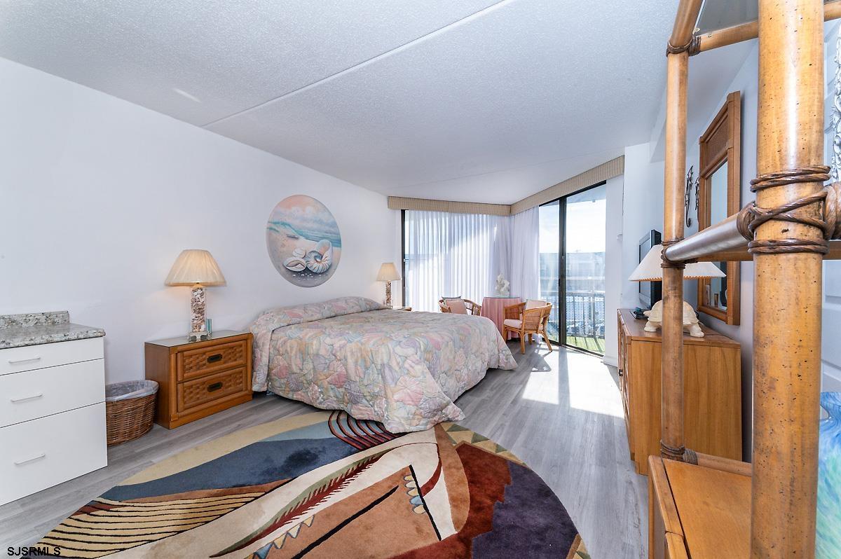 935 Ocean Avenue, Unit 315 Ocean City, NJ 08226 - Photo 18 of 37 a bed room with a bed and a lamp