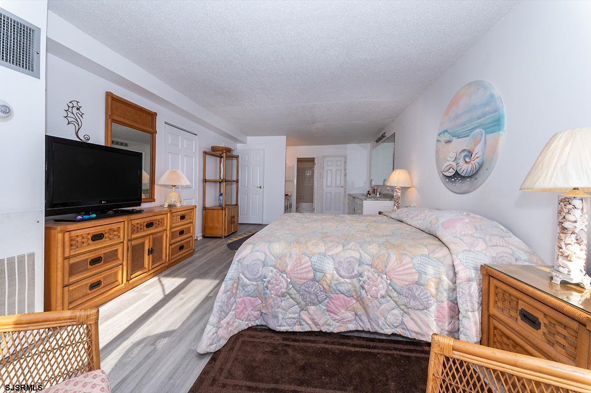 935 Ocean Avenue, Unit 315 Ocean City, NJ 08226 - Photo 21 of 37 a bed room with furniture and a flat screen tv