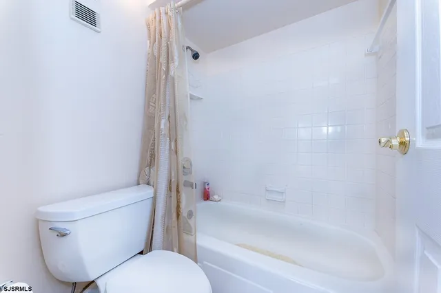 a white toilet sitting next to a bath tub