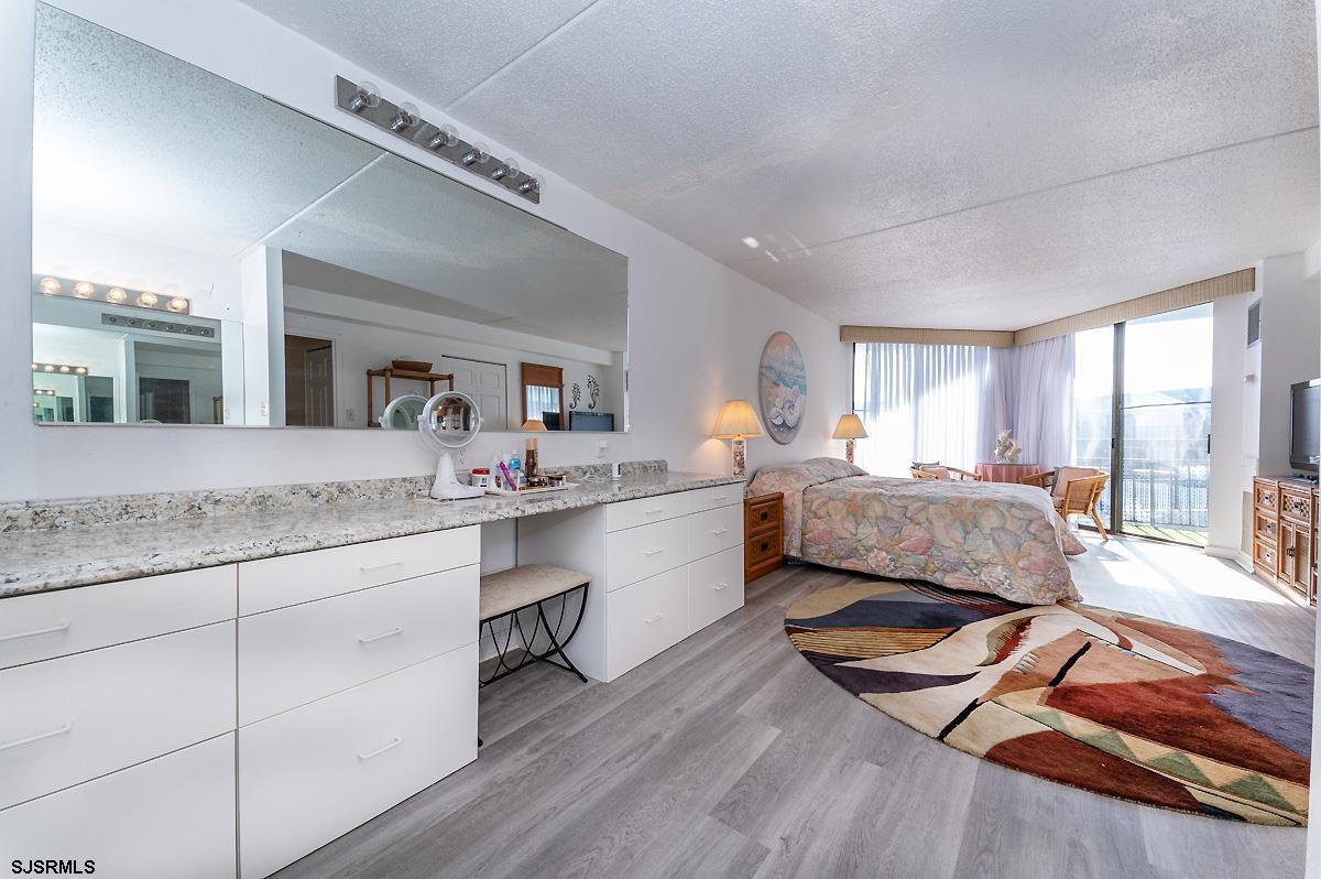 935 Ocean Avenue, Unit 315 Ocean City, NJ 08226 - Photo 24 of 37 a spacious bedroom with a bed a window and dresser