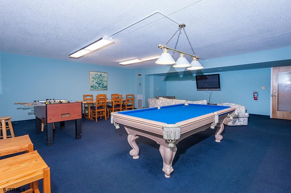 935 Ocean Avenue, Unit 315 Ocean City, NJ 08226 - Photo 33 of 37 a room with furniture pool table gym equipment and a chandelier