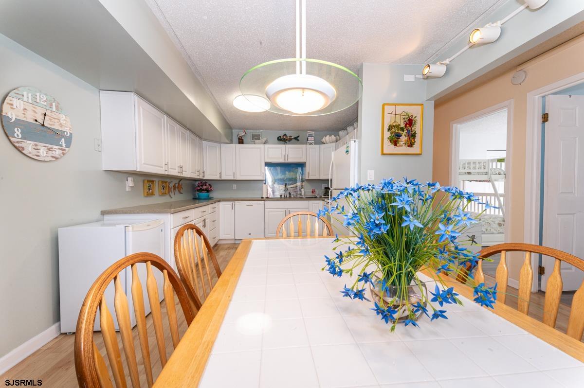 935 Ocean Avenue, Unit 315 Ocean City, NJ 08226 - Photo 9 of 37 a view of a kitchen area kitchen island stainless steel appliances table and chairs
