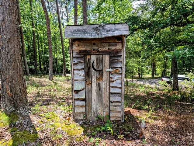 a outdoor dining room with furniture a chandelier and wooden floor