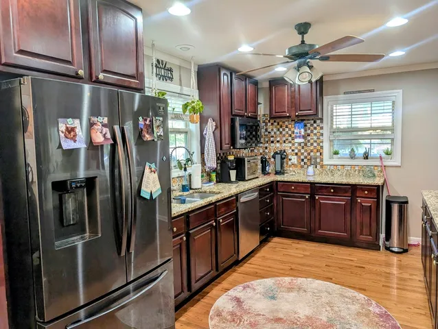 a bathroom with a sink a toilet a mirror and a window