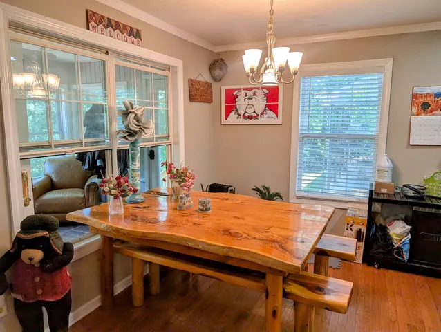 a view of staircase with lots of frames on wall and wooden floor