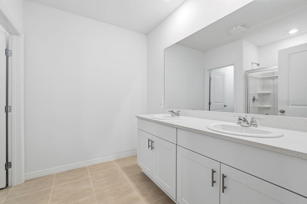 13640 Tropical Breeze Way Hudson, FL 34669 - Photo 19 of 48 a bathroom with double sink and a mirror