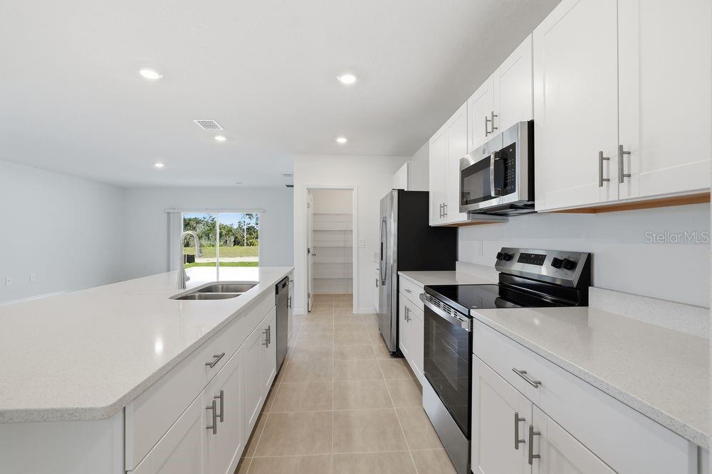 13640 Tropical Breeze Way Hudson, FL 34669 - Photo 6 of 48 a kitchen with stainless steel appliances granite countertop a sink and stove top oven