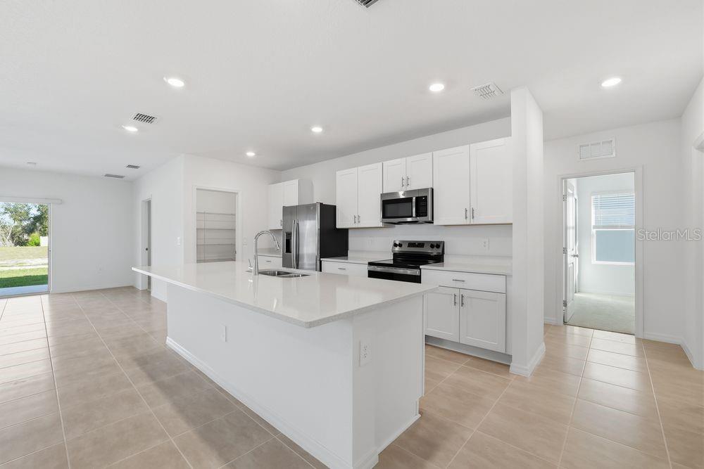 13640 Tropical Breeze Way Hudson, FL 34669 - Photo 7 of 48 a kitchen with stainless steel appliances a refrigerator sink and microwave