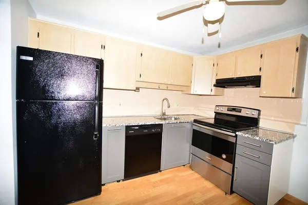 a kitchen with stainless steel appliances granite countertop a refrigerator a sink and a stove