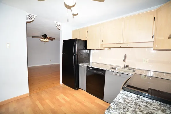a kitchen with stainless steel appliances granite countertop a refrigerator and a sink