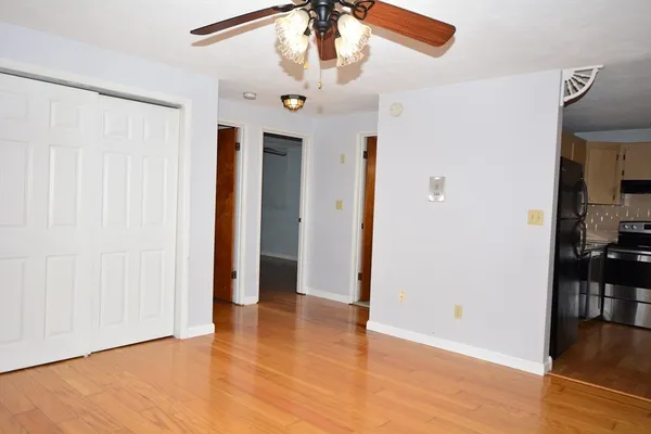 a view of an empty room with window and wooden floor