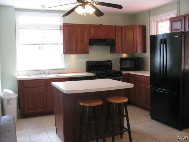 621 Friedensburg Road Reading, PA 19606 - Photo 5 of 17 a kitchen with stainless steel appliances a table chairs and a refrigerator