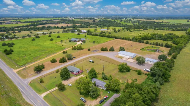 an aerial view of residential houses with outdoor space and street view