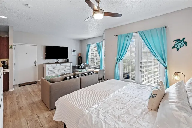 a bedroom with furniture a flat screen tv and a fireplace