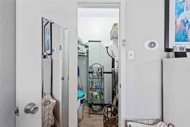 walk in closet with view of bathroom