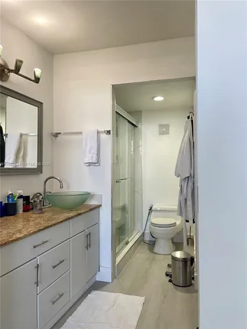 a spacious bathroom with a granite countertop sink toilet and shower