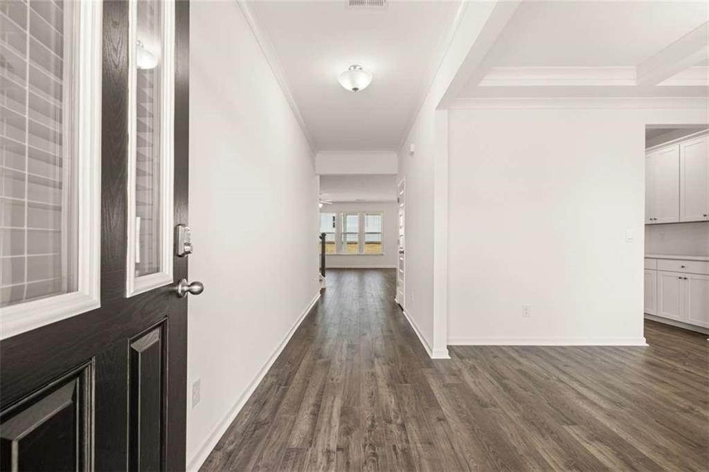 1851 Lacebark Elm Way Lawrenceville, GA 30045 - Photo 11 of 63 a view of a hallway with wooden floor and staircase