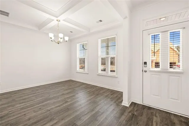 a view of a hallway with wooden floor and a chandelier