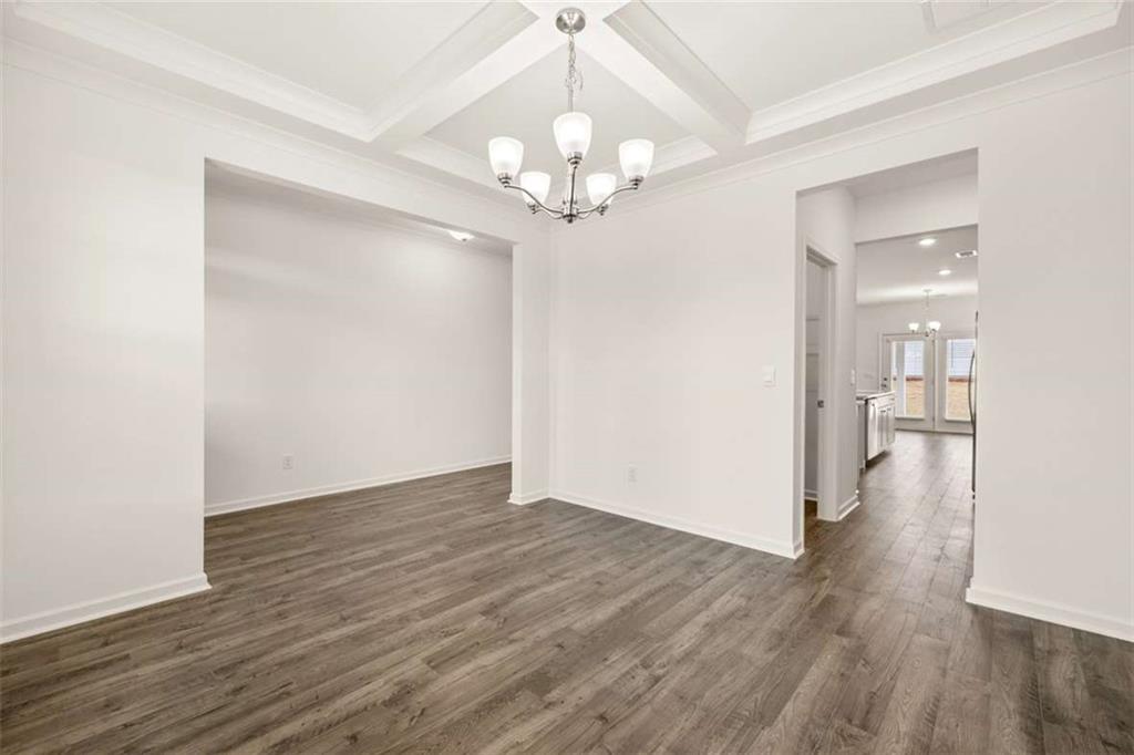 1851 Lacebark Elm Way Lawrenceville, GA 30045 - Photo 13 of 63 a view of a hallway with wooden floor and a chandelier