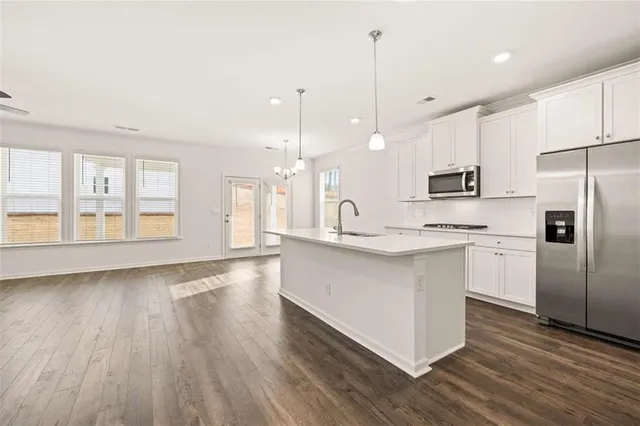 a kitchen with white cabinets and stainless steel appliances