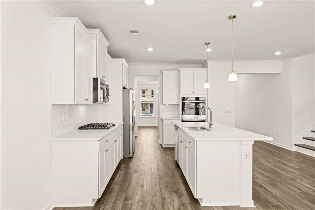 1851 Lacebark Elm Way Lawrenceville, GA 30045 - Photo 17 of 63 a kitchen with stainless steel appliances a sink stove and refrigerator