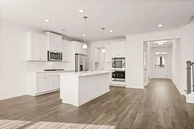 a view of an empty room with wooden floor fireplace and a window