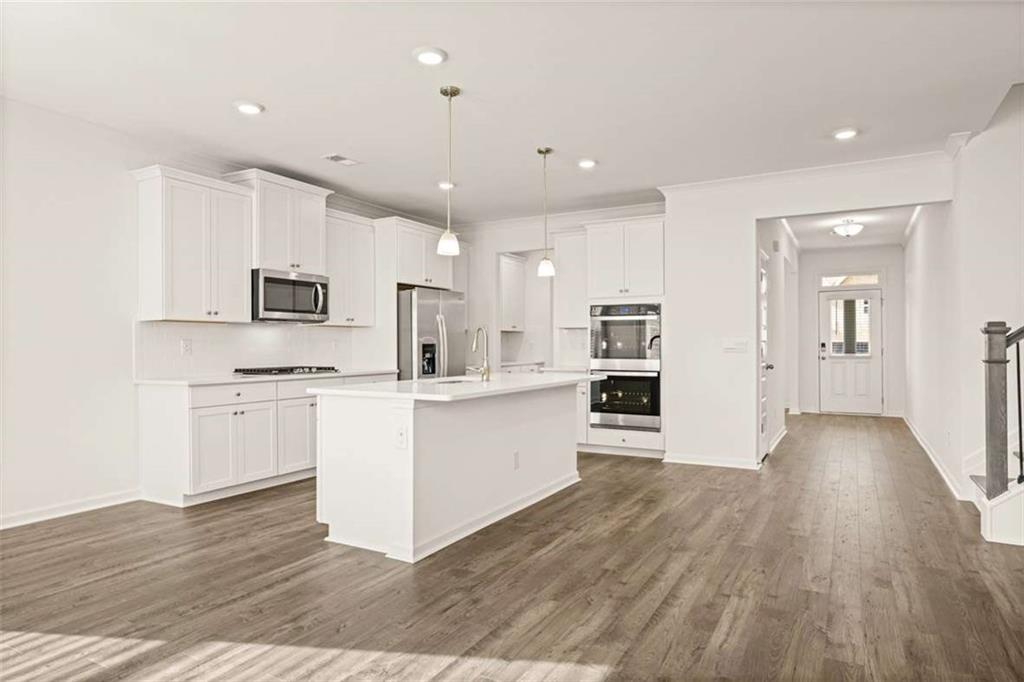 1851 Lacebark Elm Way Lawrenceville, GA 30045 - Photo 18 of 63 a kitchen with white cabinets and stainless steel appliances